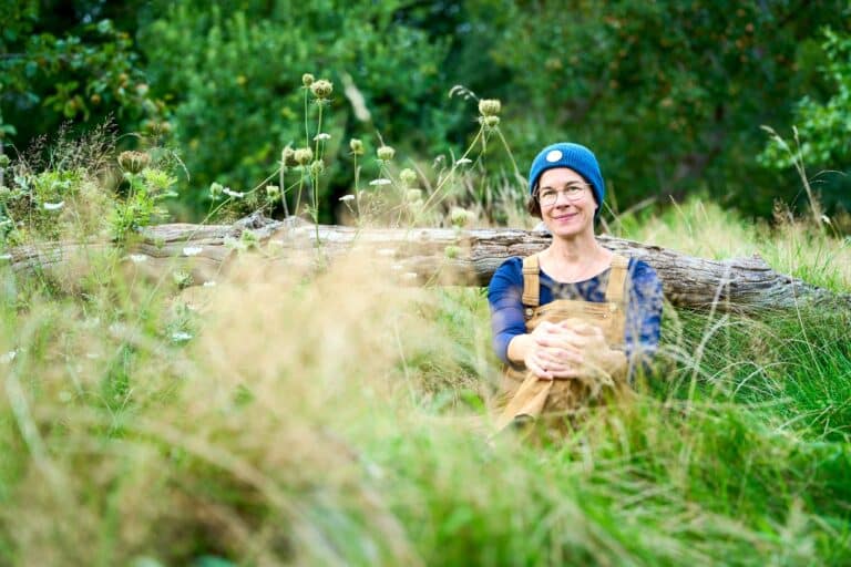 Business Portrait einer Frau sitzend im Gras